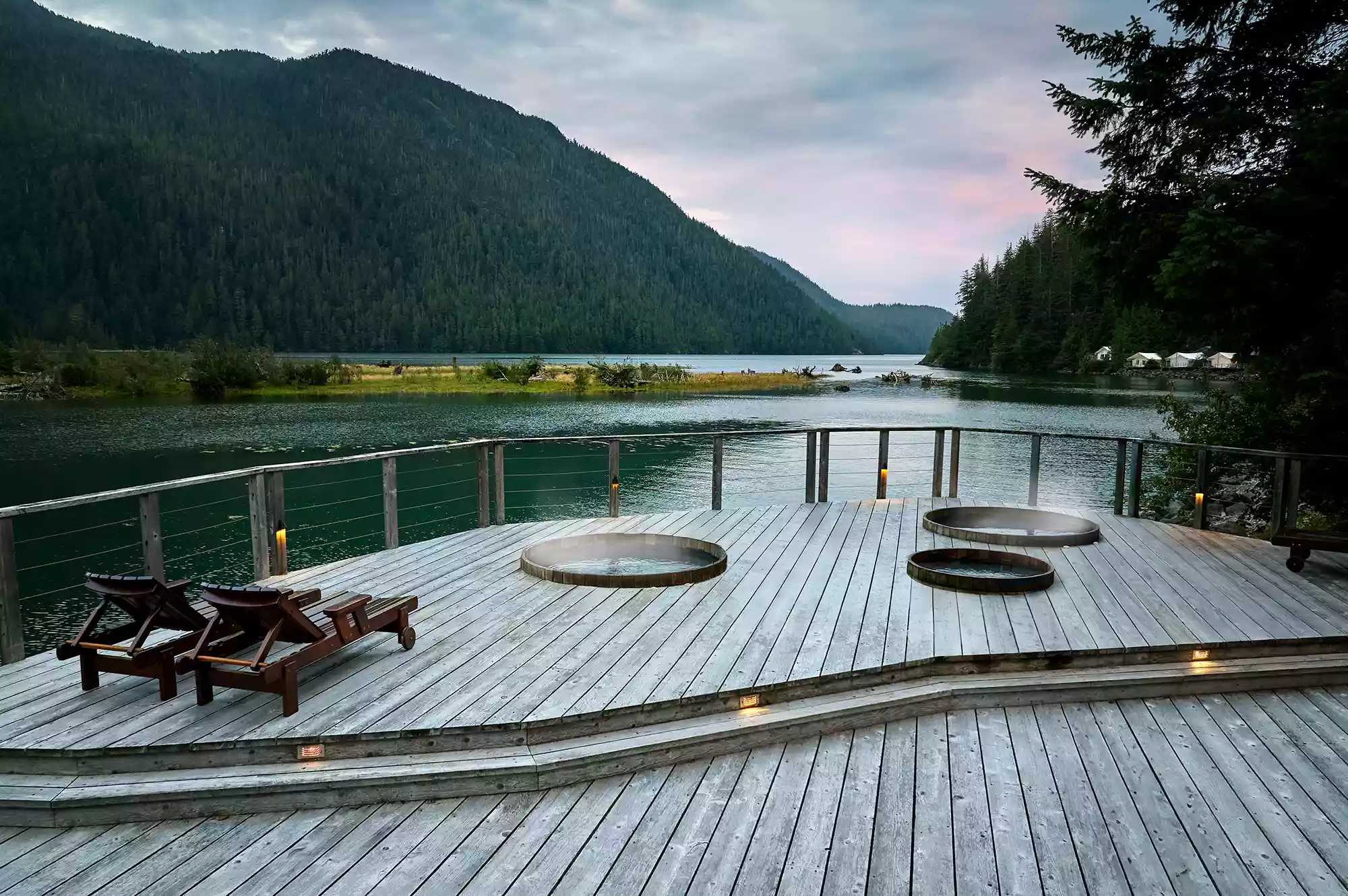 A serene wooden spa deck with lounge chairs and wellness facilities tucked into the forest.