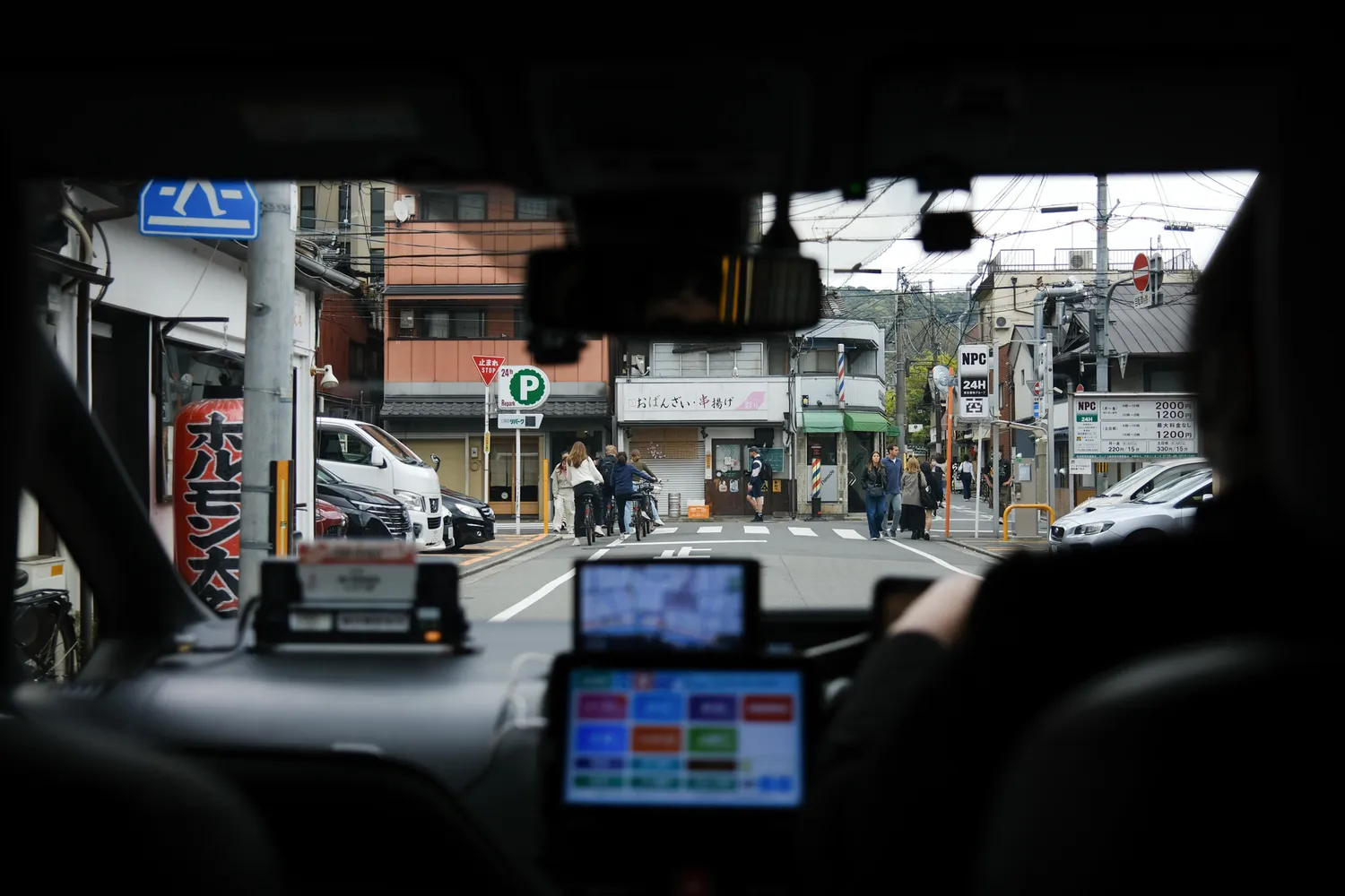 A view of the Kyoto streetscape seen from the passenger seat of a local taxi.