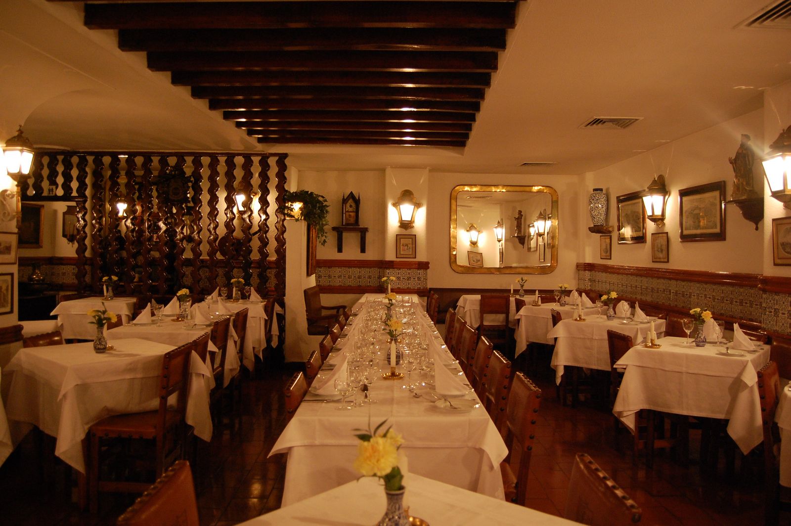 An intimate, candlelit dining hall in Lisbon with warm lighting and a quiet atmosphere.