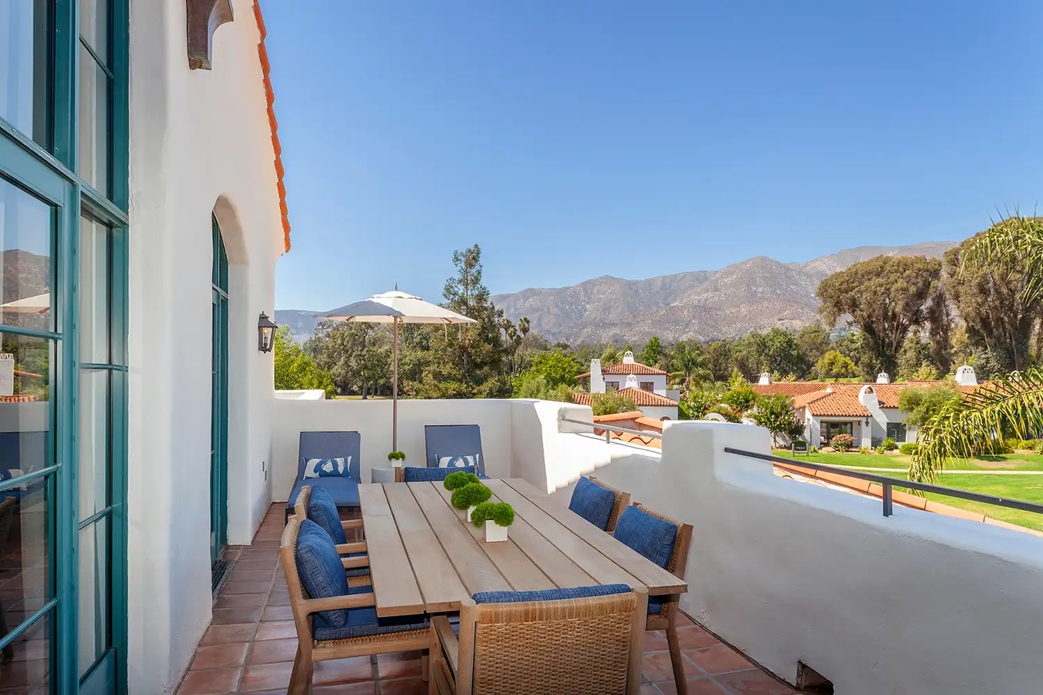A private guest terrace at Ojai Valley Inn overlooking landscaped gardens and distant mountain peaks.