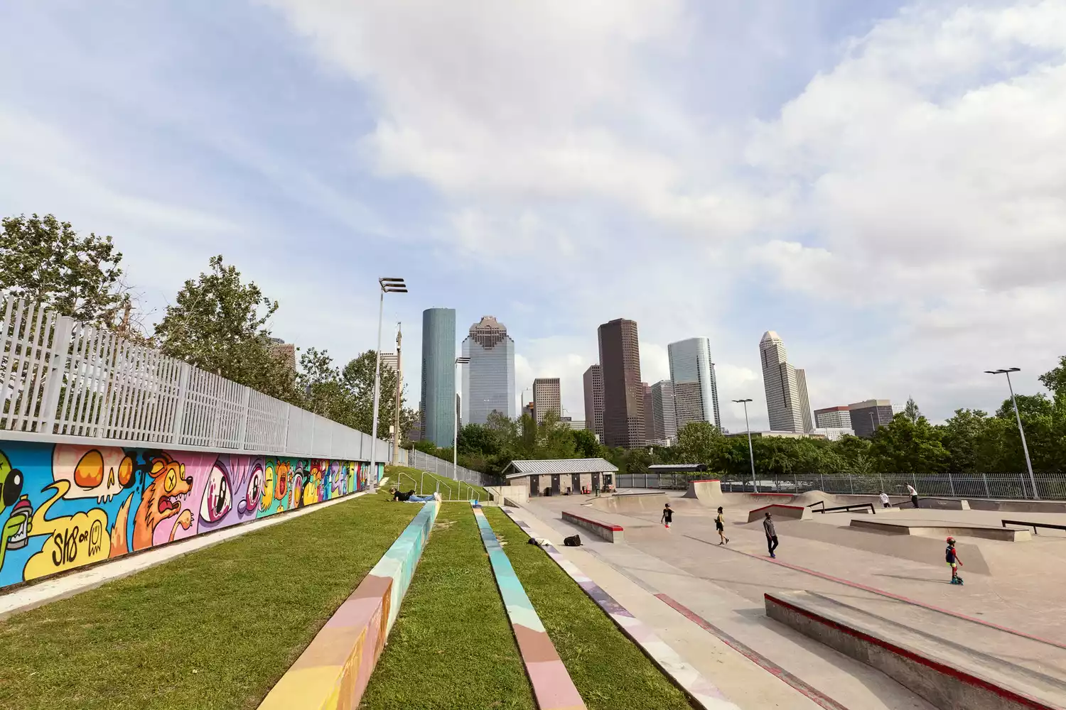 The Houston city skyline viewed from a public park at dusk.