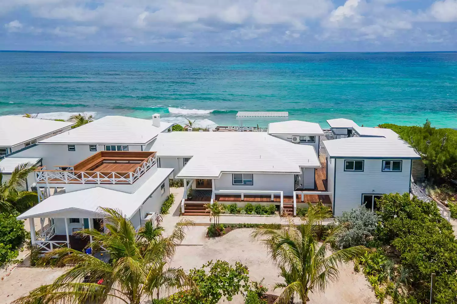 High-angle aerial shot of a boutique property surrounded by crystal clear Bahamian waters.