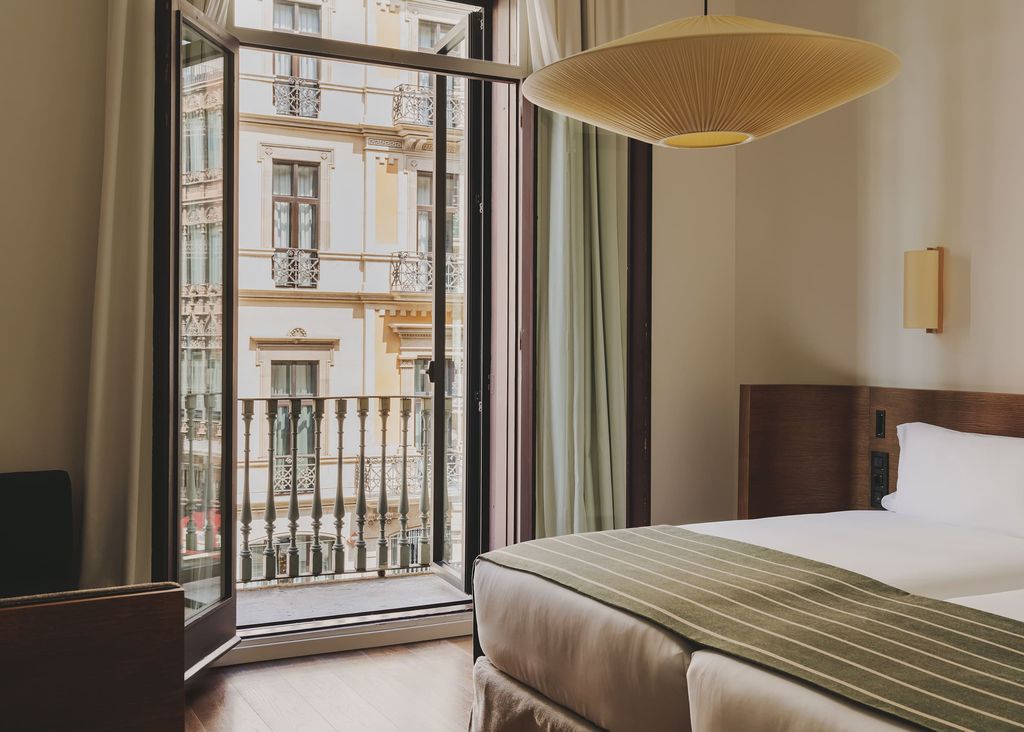 Modernist interior of a guest room at Hotel Regina featuring oak accents and large windows.
