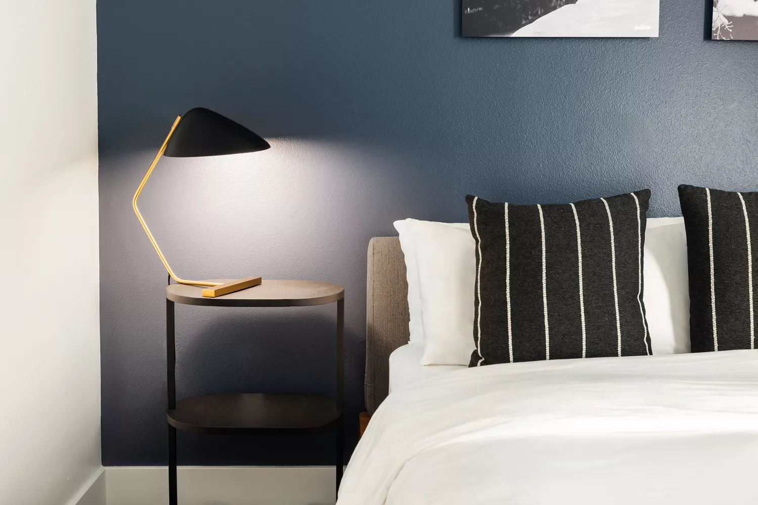 Close-up of a modern bed and wooden nightstand at Gravity Haus Truckee Tahoe.