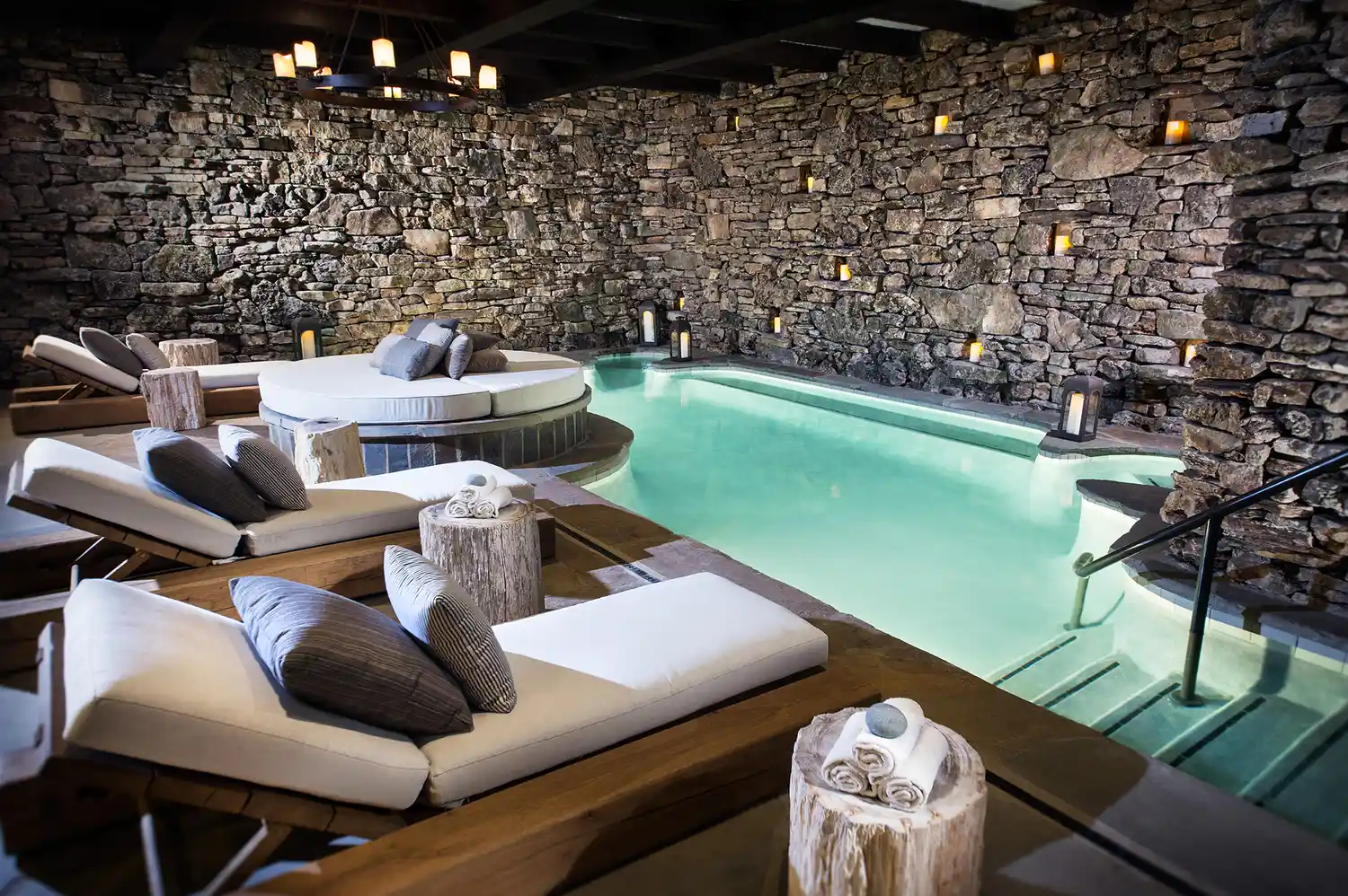 Luxurious indoor grotto pool at Cedar Creek Spa with stone walls and ambient lighting.