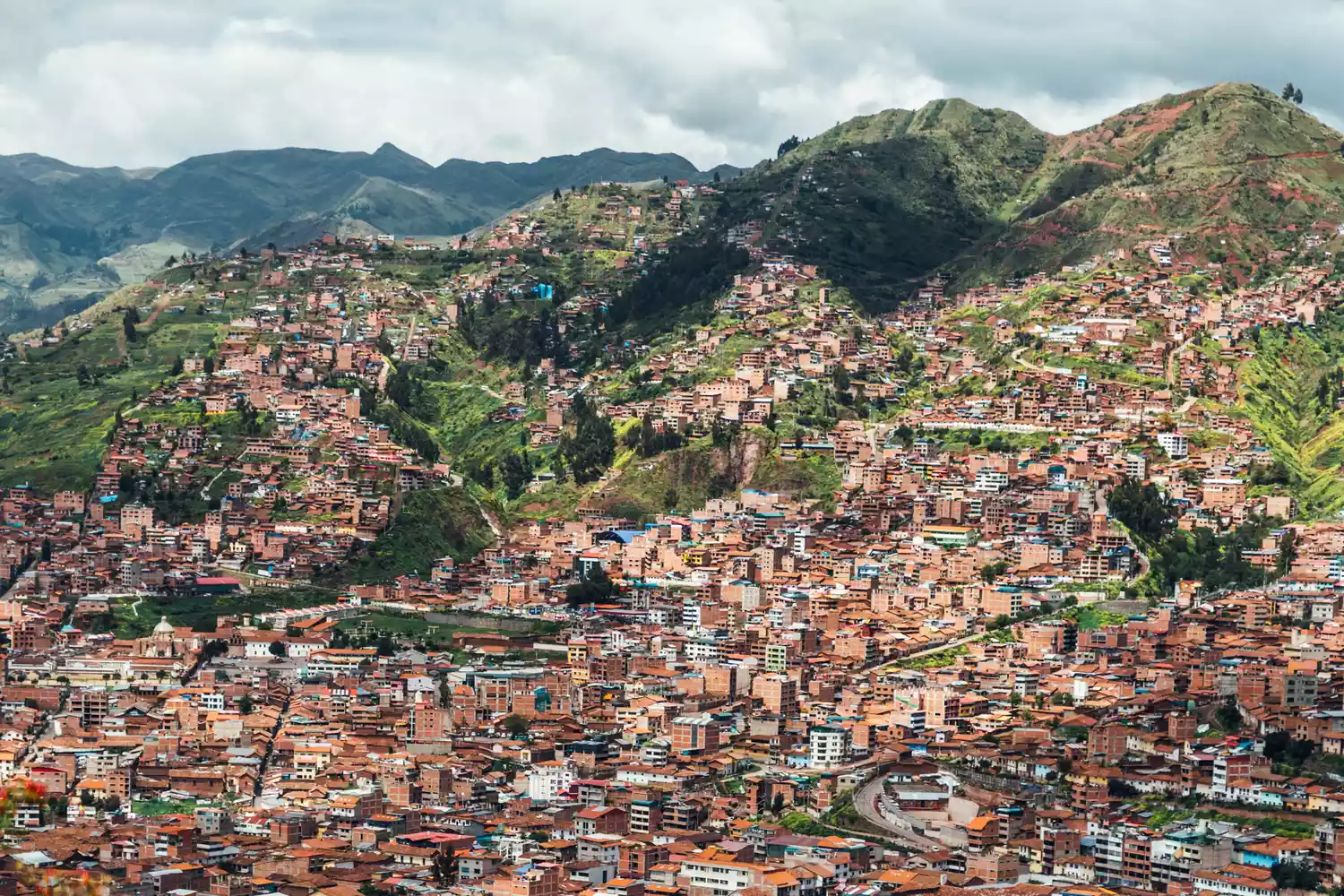 Aerial view of Cuzco, Peru, showcasing the terracotta rooftops and historic plazas nestled in the Andes.