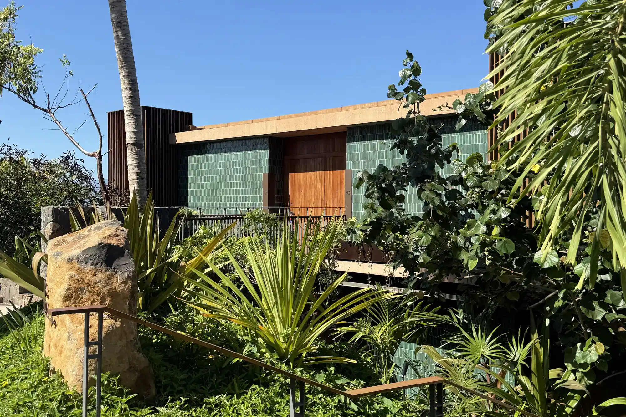 Exterior view of a luxury suite at Siari surrounded by tropical greenery and palm trees.