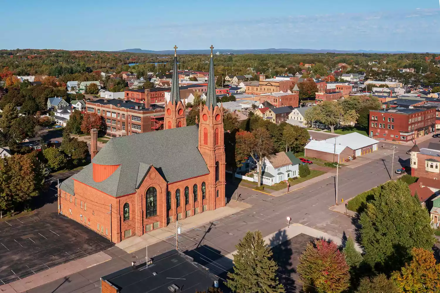 Aerial overview of the historic town of Calumet, Michigan, surrounded by northern forests.