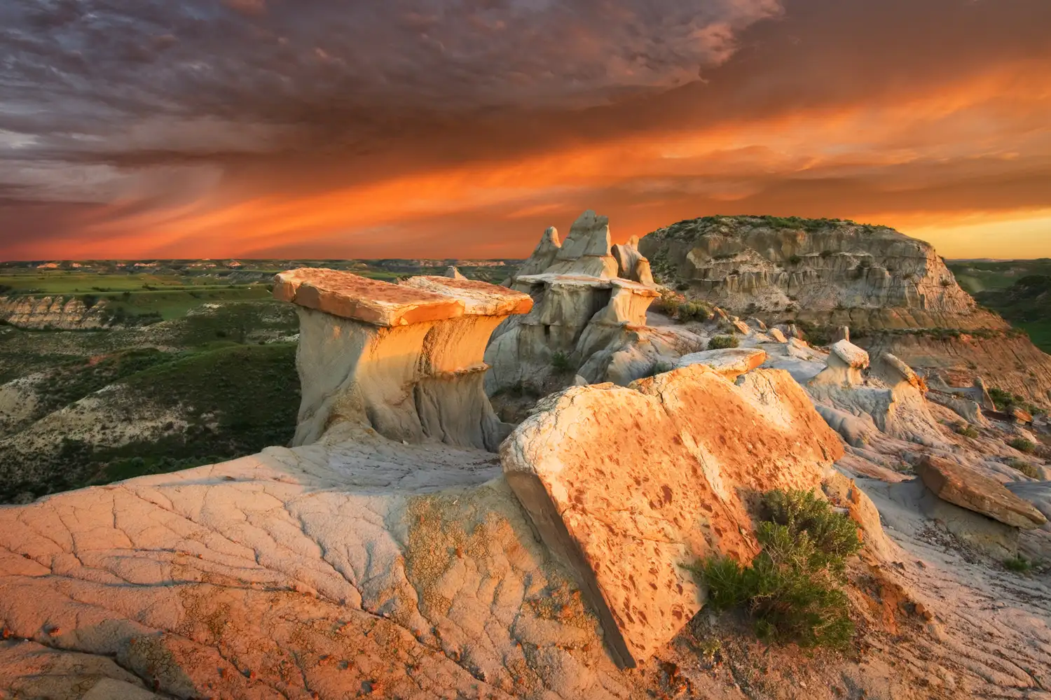 Dramatic sunrise casting golden light over the canyons and ridges of the North Dakota Badlands.