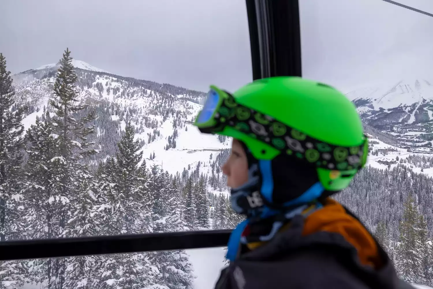A young child skier sitting on a chairlift at Red Lodge Mountain.