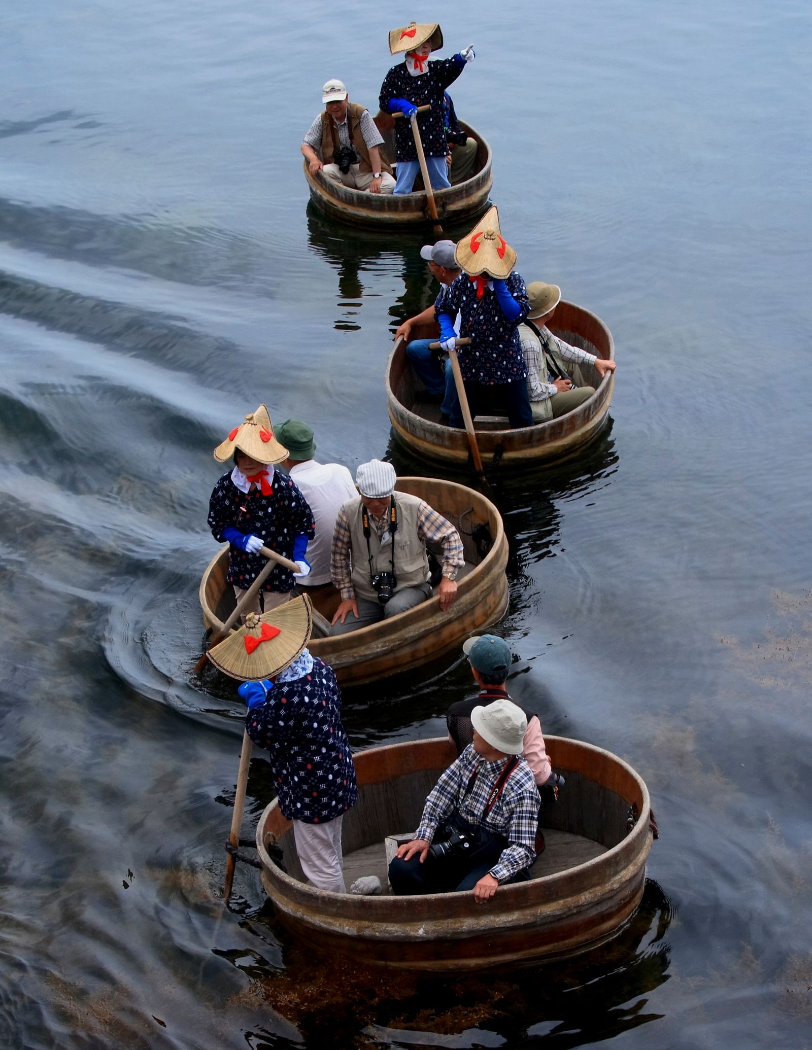 A person rowing a traditional round washtub boat or rowboat.