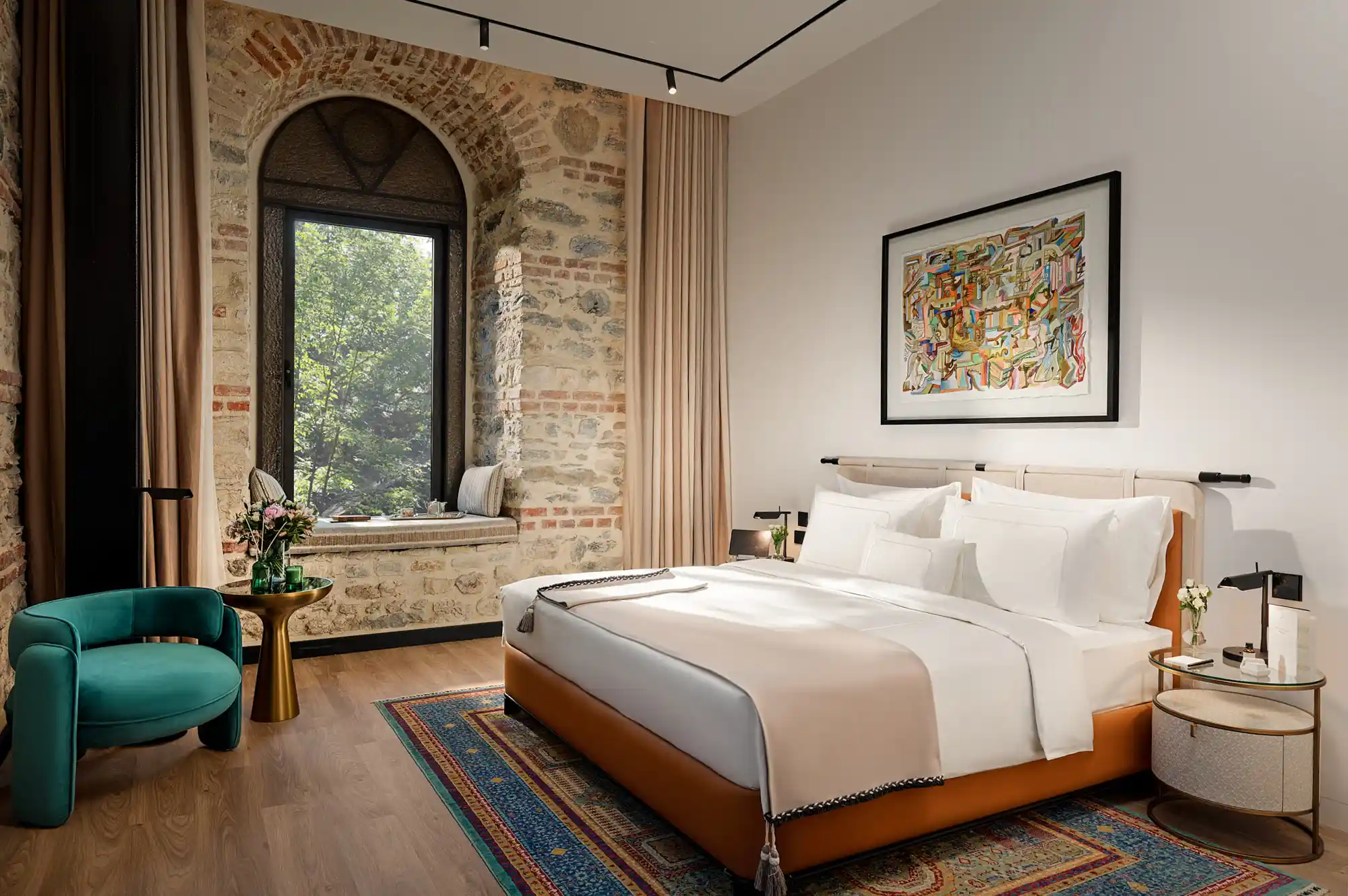 A modern luxury hotel room at Aliée Istanbul featuring contemporary furniture and a large window with city views.