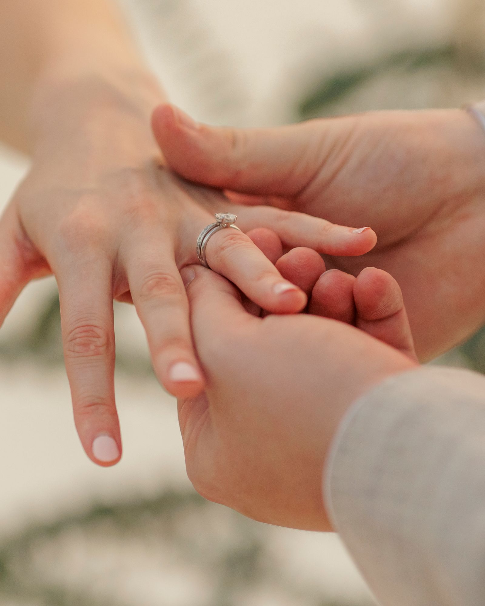 A close-up of a wedding ring being placed on a finger during a ceremony.