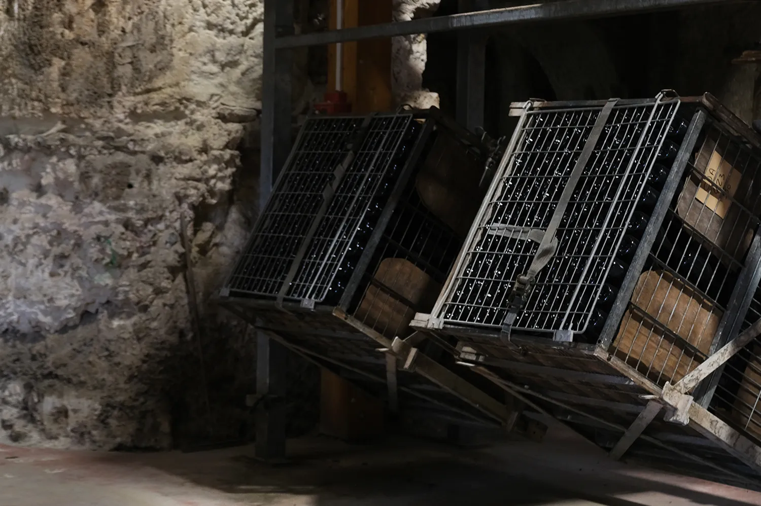 Stacked wine crates in a traditional stone wine cellar in the Loire region.