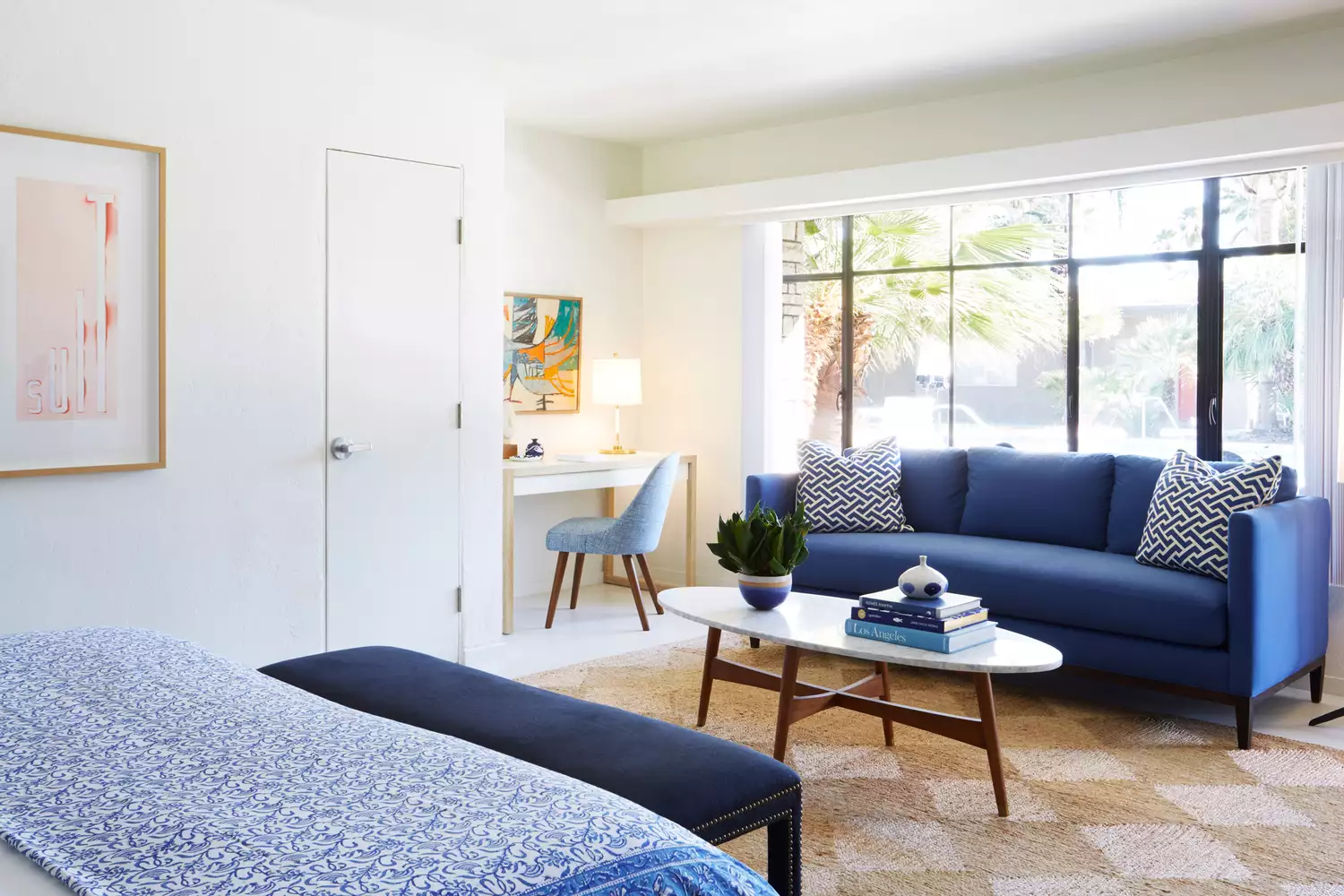 Brightly decorated guest room at Holiday House featuring blue accents and mid-century art.
