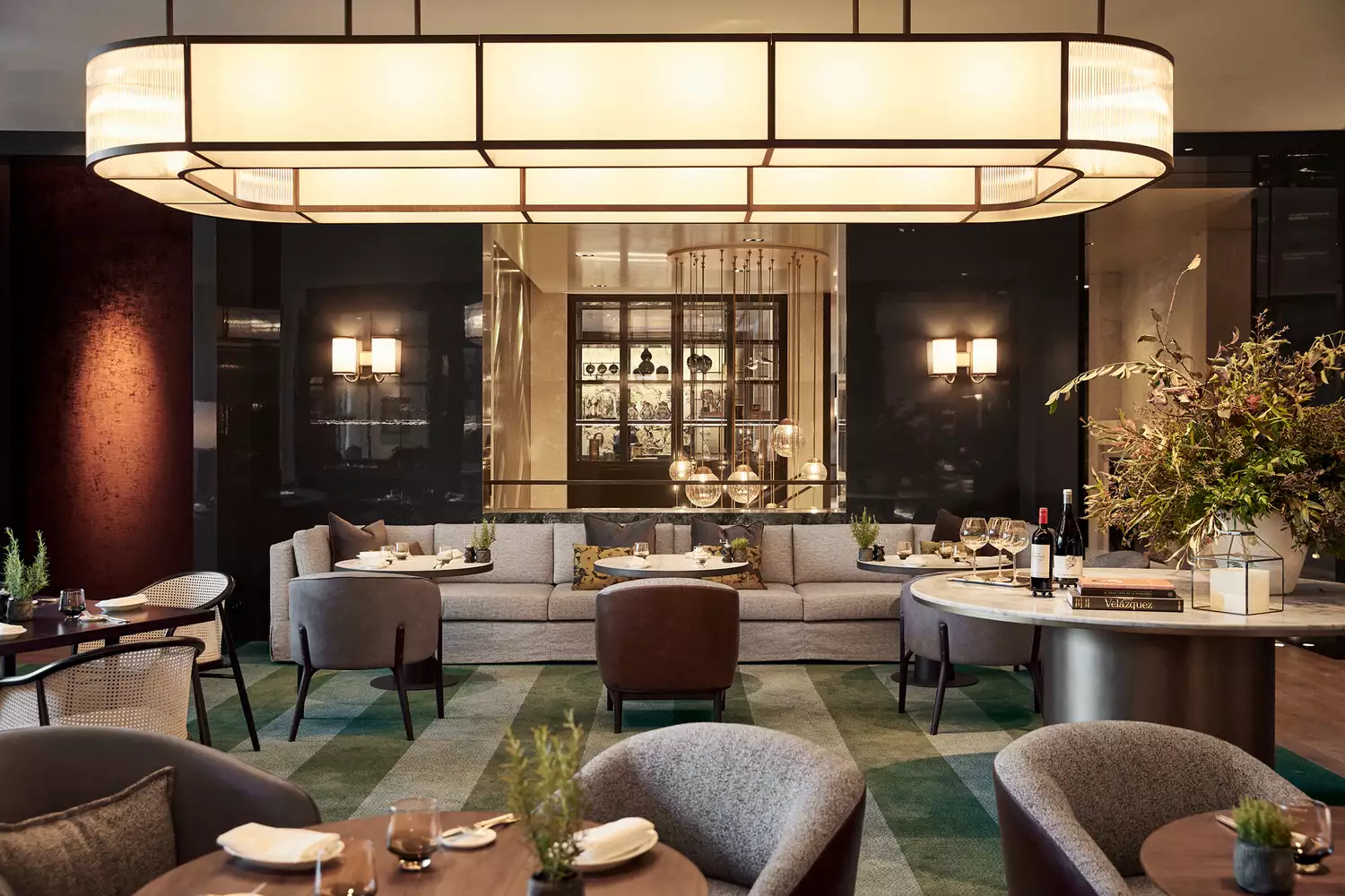 The chic bar and lounge area at the Rosewood Villa Magna hotel in Madrid, featuring modern decor.