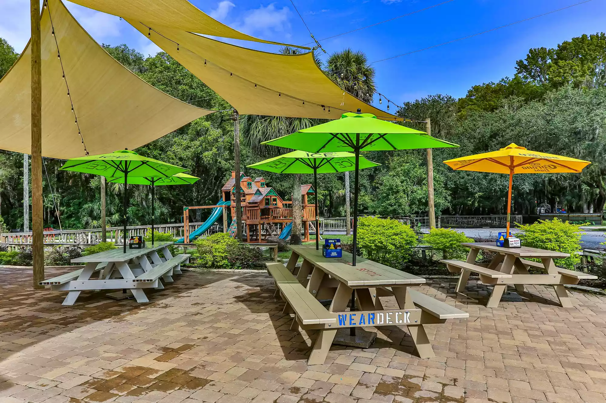 Waterfront outdoor dining area at The Cove Pub featuring wooden tables overlooking the lake.