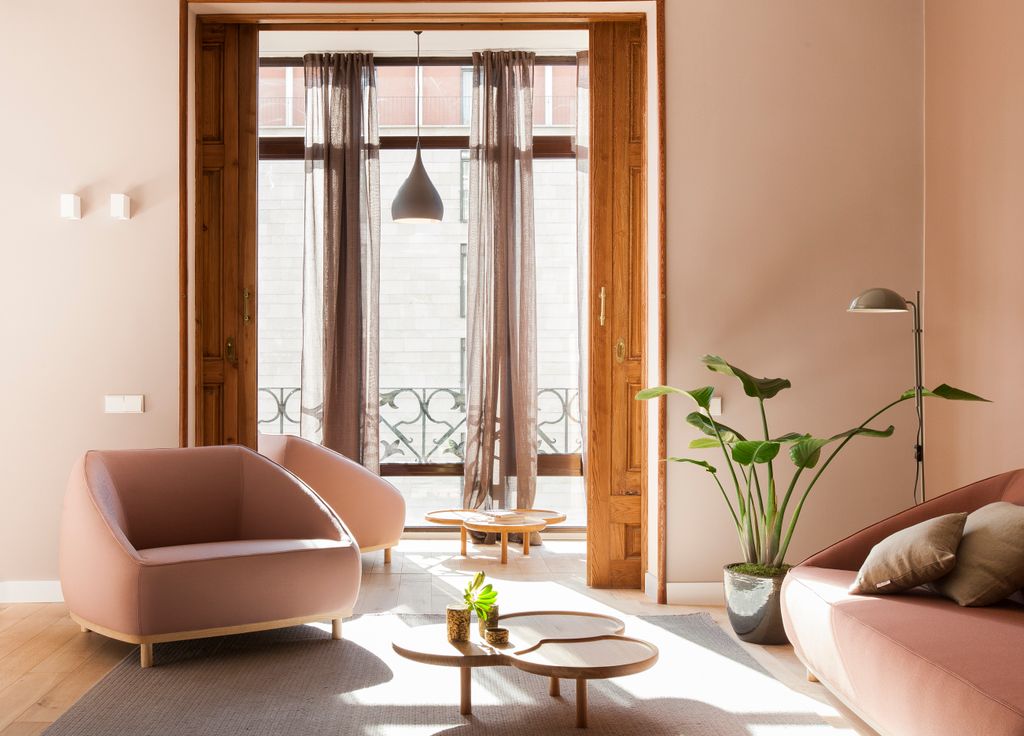 A bright, mid-century modern living area in a Destination BCN apartment with exposed white brick walls.